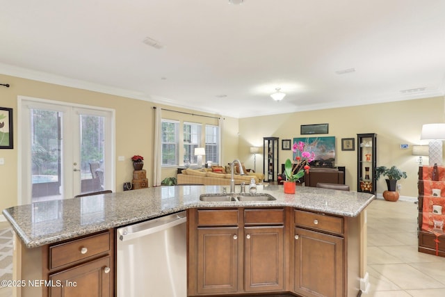 kitchen featuring dishwasher, light stone countertops, sink, and an island with sink