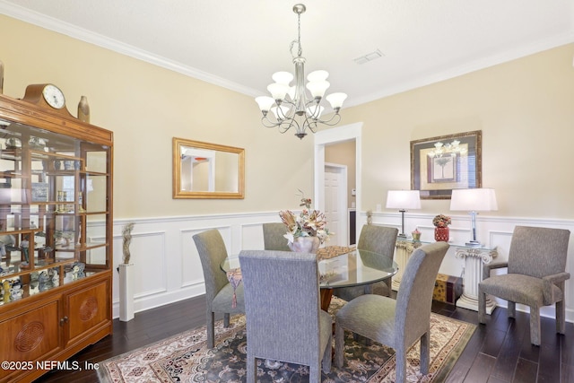 dining space with ornamental molding, dark hardwood / wood-style floors, and a chandelier