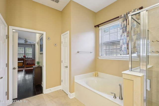 bathroom with tile patterned floors, independent shower and bath, and a healthy amount of sunlight