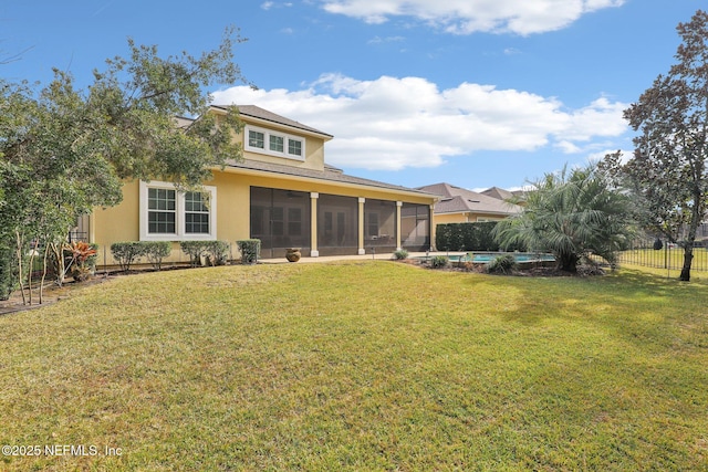 back of property featuring a sunroom, a swimming pool, and a lawn