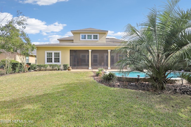 rear view of property featuring a yard and a sunroom