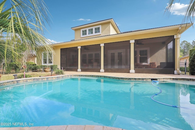 view of swimming pool featuring a sunroom and ceiling fan