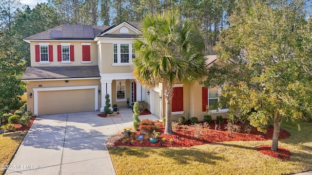 view of front of property featuring a garage, a front yard, and solar panels