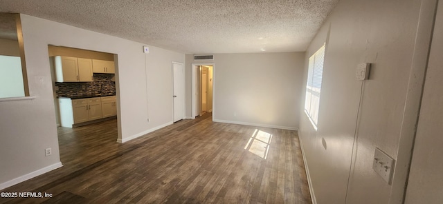 unfurnished room featuring a textured ceiling and dark wood-type flooring