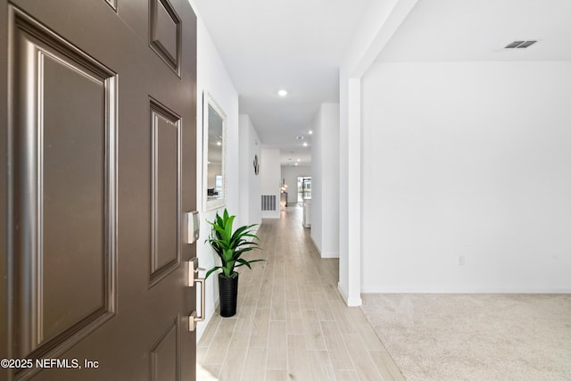 hallway with light hardwood / wood-style floors