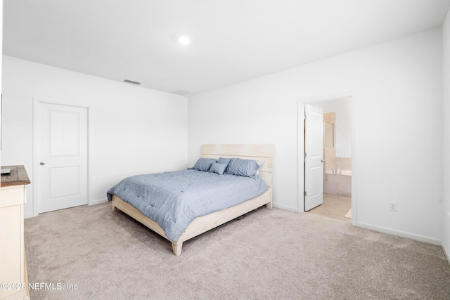 carpeted bedroom featuring ensuite bath