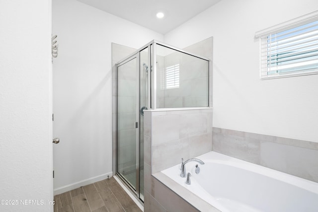 bathroom featuring hardwood / wood-style flooring and separate shower and tub