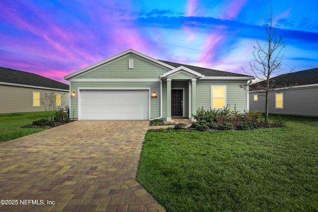 view of front of house featuring a garage and a lawn