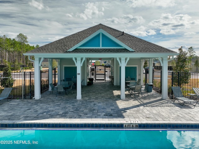 back of property with a fenced in pool, a gazebo, and a patio area