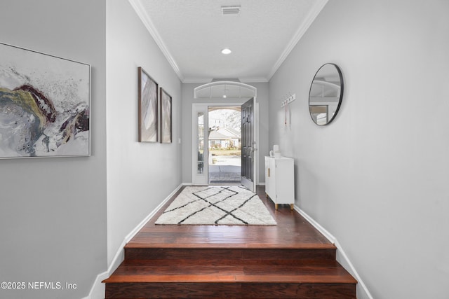 entryway with hardwood / wood-style flooring, crown molding, and a textured ceiling