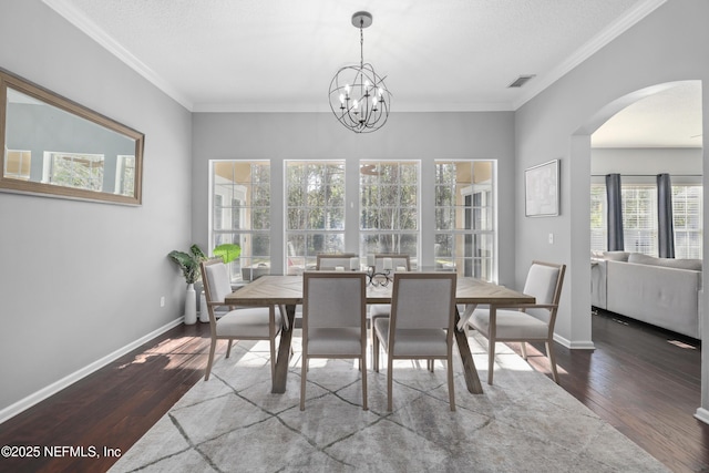 dining area featuring hardwood / wood-style floors, crown molding, and a textured ceiling