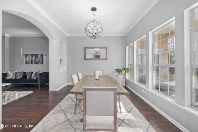 dining space featuring a notable chandelier, dark wood-type flooring, and ornamental molding