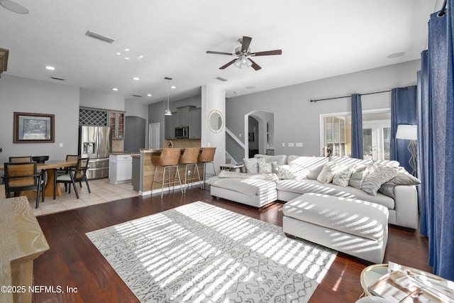 living room featuring ceiling fan and dark hardwood / wood-style flooring