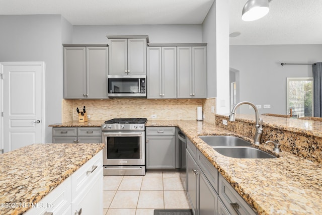 kitchen featuring light tile patterned flooring, appliances with stainless steel finishes, sink, and decorative backsplash