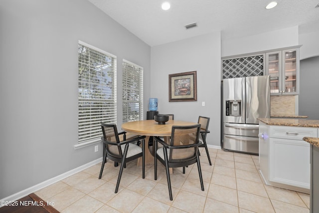 tiled dining space featuring a textured ceiling