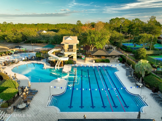 view of swimming pool with a water slide and a patio area