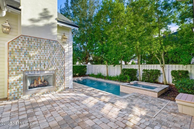 view of swimming pool featuring a patio area and an in ground hot tub