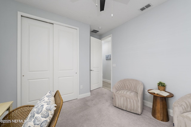 sitting room featuring ceiling fan and light carpet