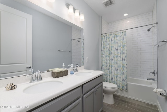 full bathroom featuring toilet, vanity, and shower / bath combination with curtain