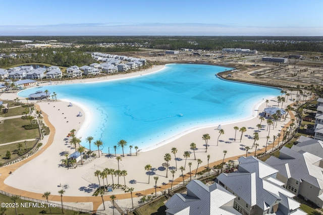 drone / aerial view featuring a beach view and a water view