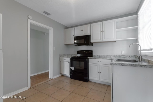 kitchen with black appliances, light tile patterned floors, a textured ceiling, white cabinets, and sink