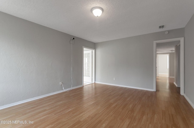 empty room with a textured ceiling and hardwood / wood-style flooring