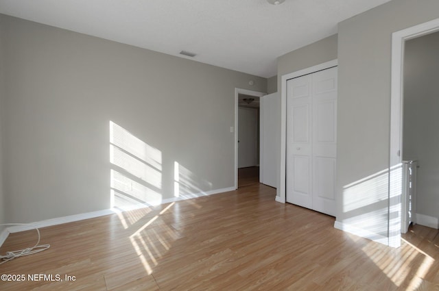 unfurnished bedroom featuring a closet and light wood-type flooring