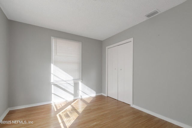 interior space with a closet, a textured ceiling, and light hardwood / wood-style flooring