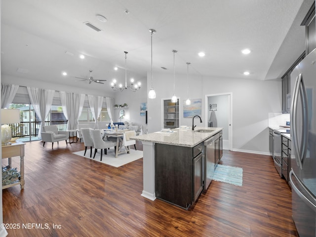 kitchen featuring an island with sink, pendant lighting, dark brown cabinetry, sink, and ceiling fan with notable chandelier