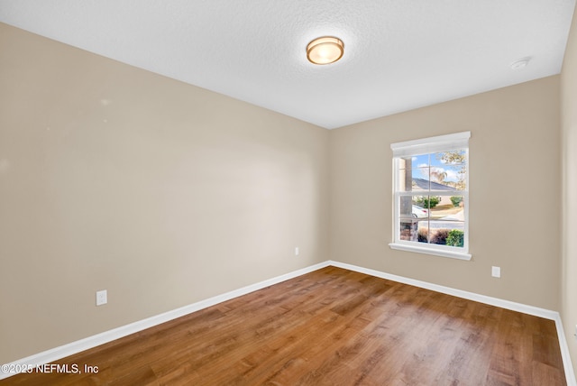 spare room featuring a textured ceiling and wood-type flooring