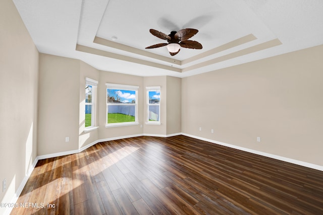 unfurnished room with hardwood / wood-style flooring, a tray ceiling, and ceiling fan