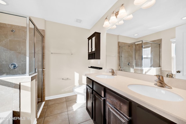 bathroom with toilet, vanity, tile patterned floors, a shower with door, and a chandelier