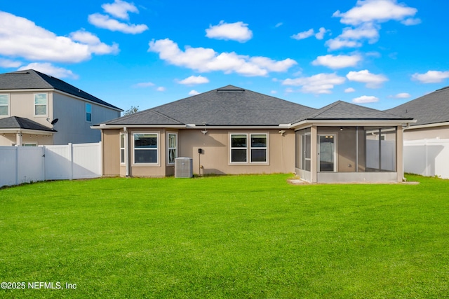 back of house featuring a sunroom, a lawn, and central air condition unit