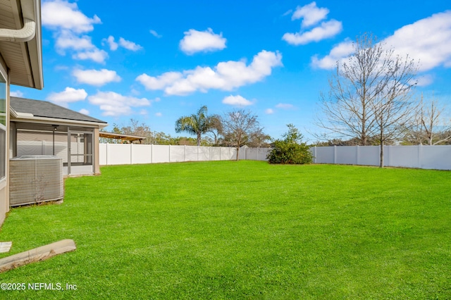 view of yard with central air condition unit and a sunroom