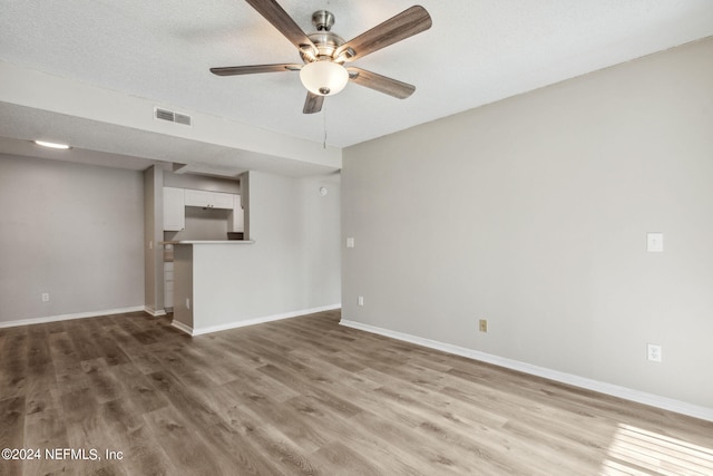 unfurnished room featuring a textured ceiling, ceiling fan, and hardwood / wood-style floors