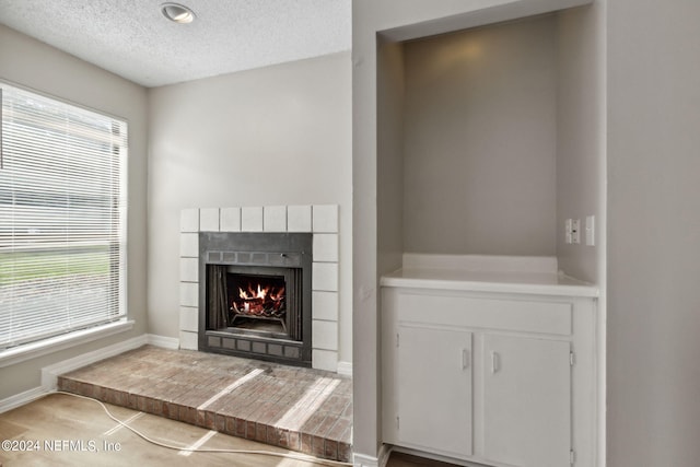 details featuring a tile fireplace and a textured ceiling