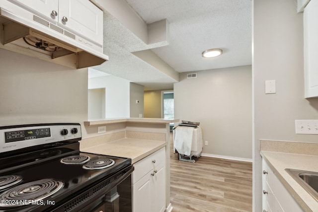 kitchen with white cabinets, a textured ceiling, electric stove, and light hardwood / wood-style floors