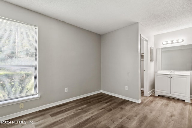 unfurnished bedroom featuring a textured ceiling and light hardwood / wood-style flooring