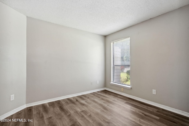 spare room featuring hardwood / wood-style flooring and a textured ceiling