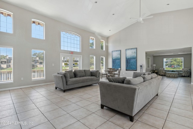 tiled living room featuring high vaulted ceiling, french doors, and ceiling fan