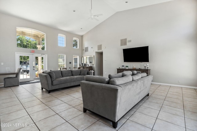 living room with a towering ceiling, french doors, and light tile patterned flooring