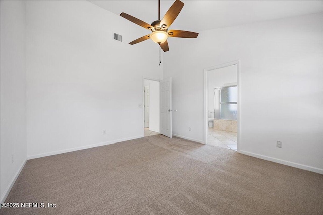 unfurnished room with a high ceiling, light colored carpet, and ceiling fan