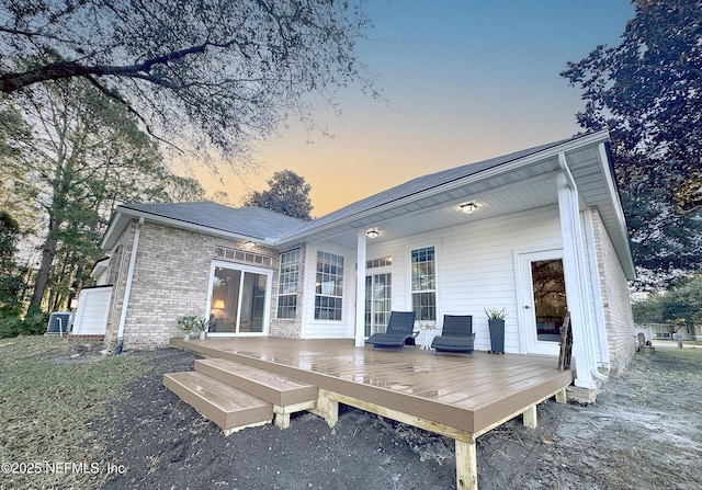 back house at dusk with a deck