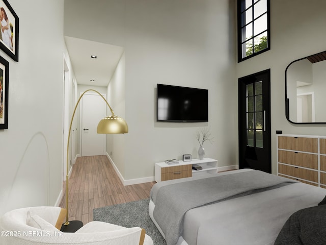 bedroom featuring a towering ceiling and hardwood / wood-style floors