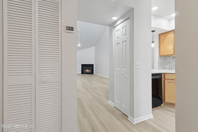 corridor featuring sink and light hardwood / wood-style flooring