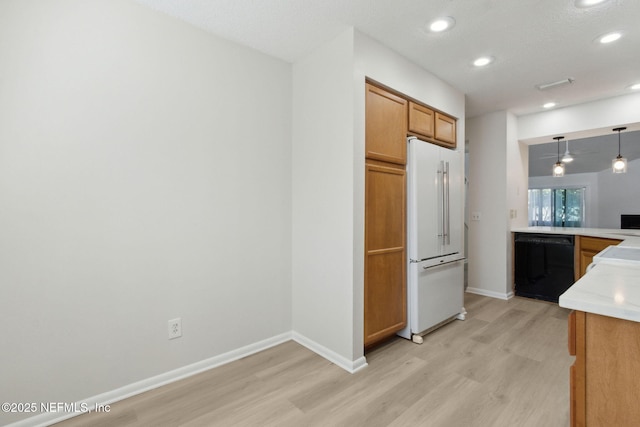 kitchen with high end white refrigerator, decorative light fixtures, black dishwasher, and light hardwood / wood-style floors