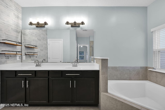 bathroom with a relaxing tiled tub and vanity