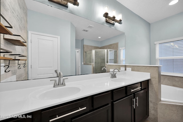 bathroom featuring vanity, shower with separate bathtub, and a textured ceiling