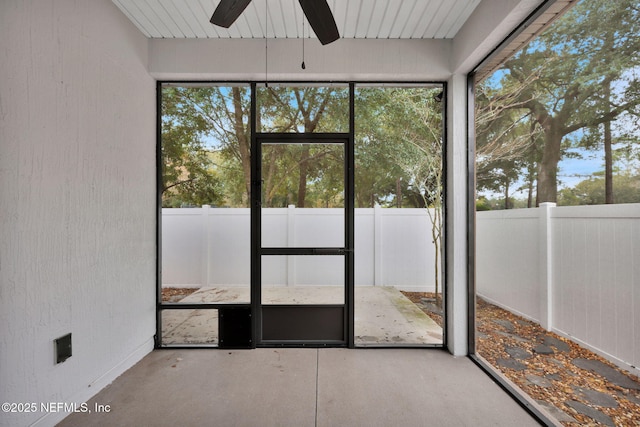 unfurnished sunroom featuring ceiling fan