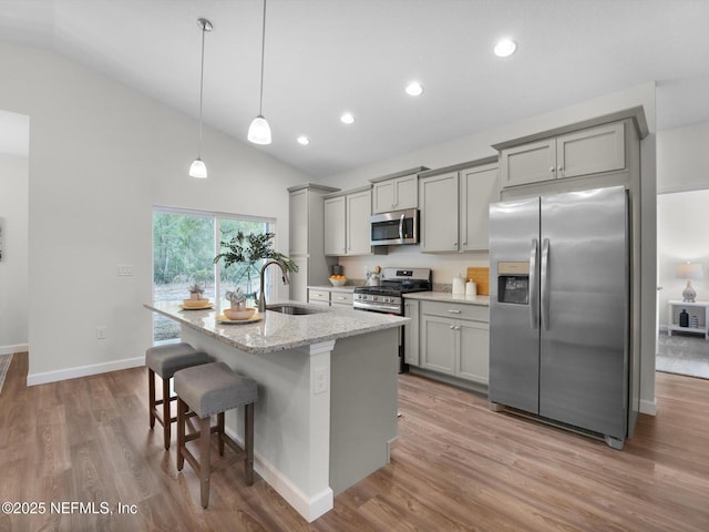 kitchen with light stone countertops, sink, appliances with stainless steel finishes, and gray cabinets